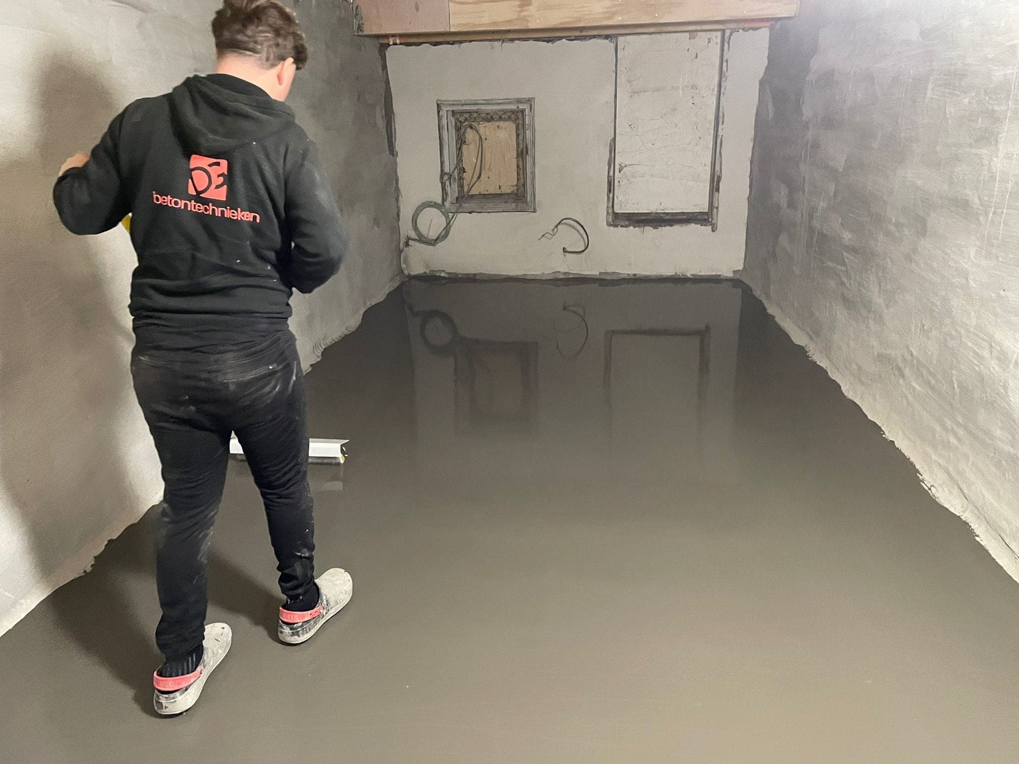 Monteur van DG Betontechnieken werkt aan de waterdichte vloer van een kelder in Rotterdam