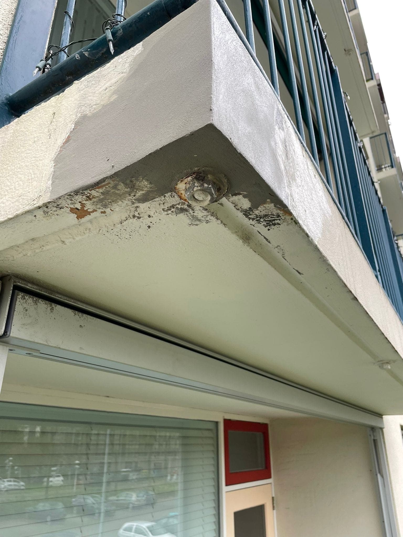 Balkonrand met betonrot en afgebrokkelde betondekking