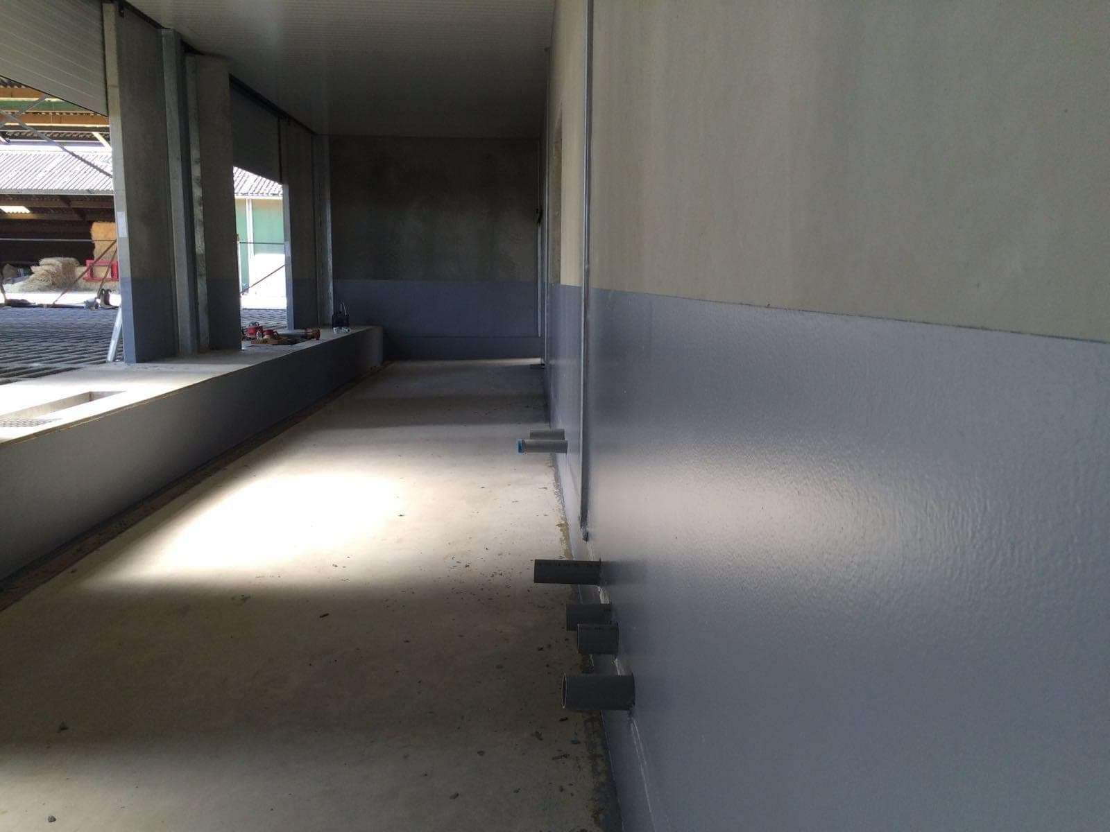 Gecoate wand en vloer in een stal