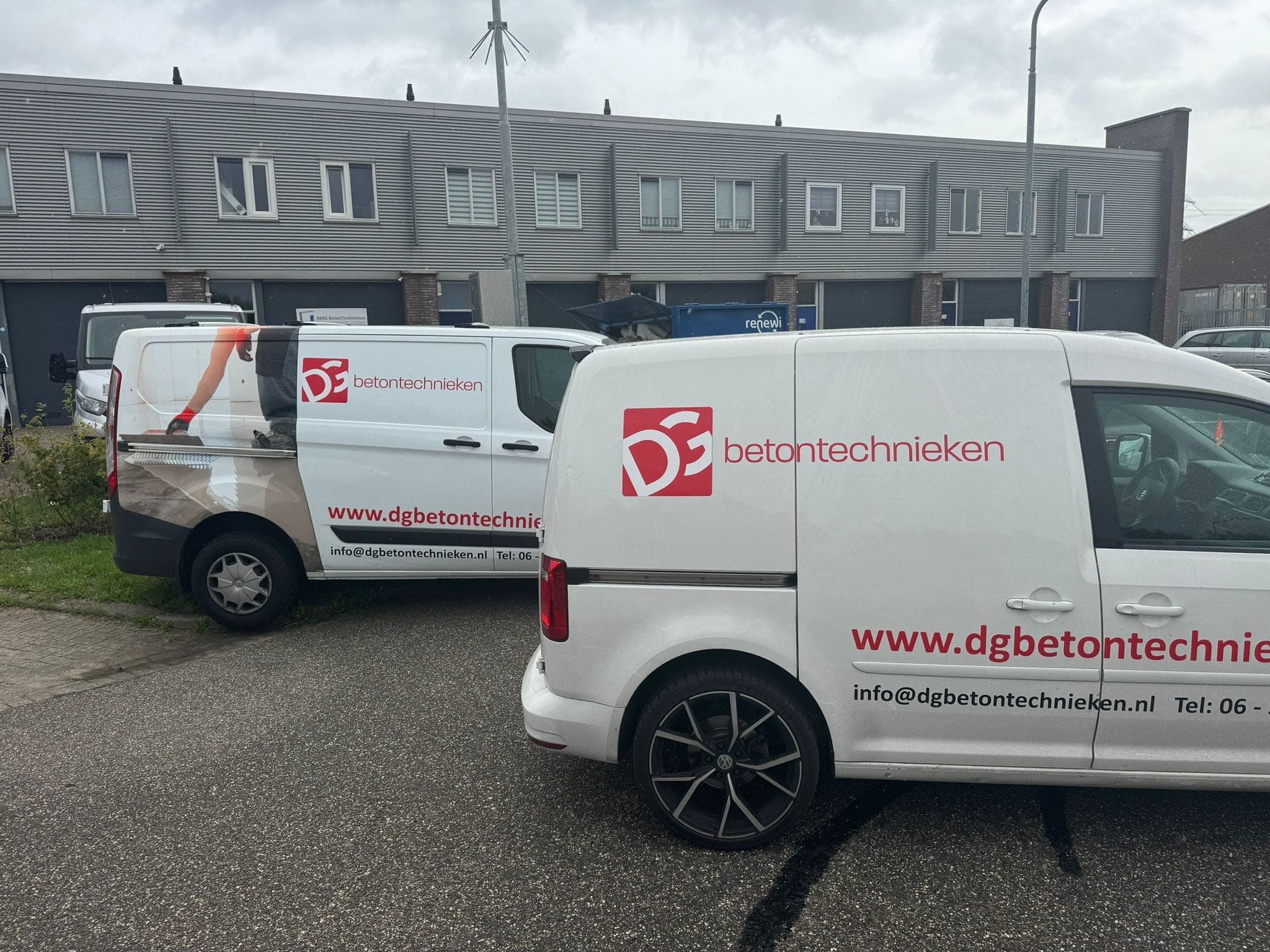 Twee bedrijfsbussen van DG Betontechnieken voor een bedrijfspand